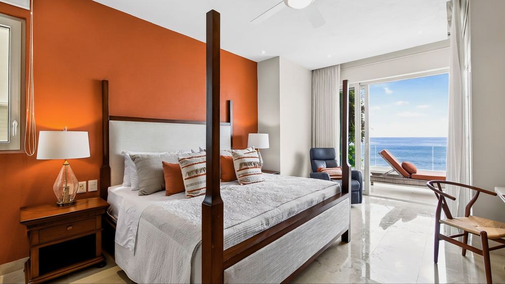 Primary bedroom with four-poster king bed and ocean-view terrace
