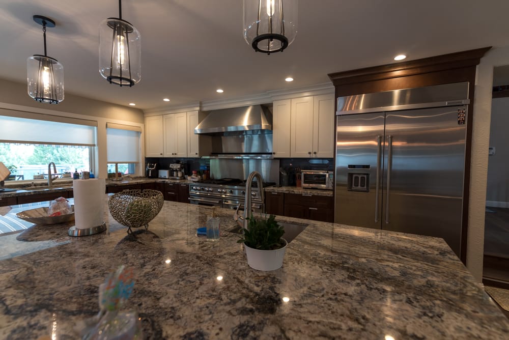 Kitchen with granite island, stainless appliances and pendant lights