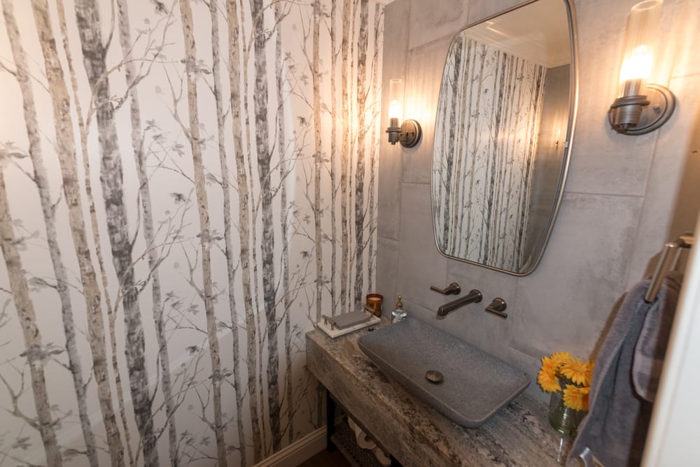 Powder room with birch-tree wallpaper and stone vessel sink