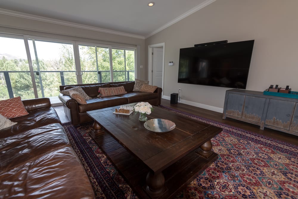Upstairs lounge with leather sofas, large TV and treetop views